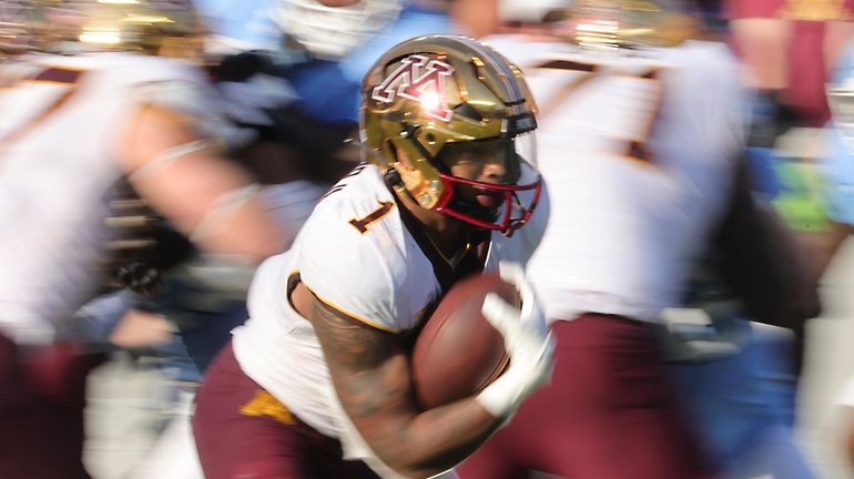 Minnesota running back Darius Taylor (1) runs the ball during...