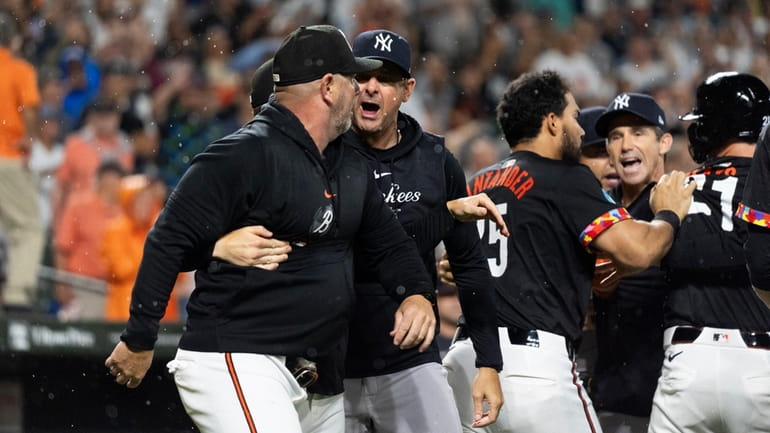 Yankees manager Aaron Boone, second from left, and Orioles major...