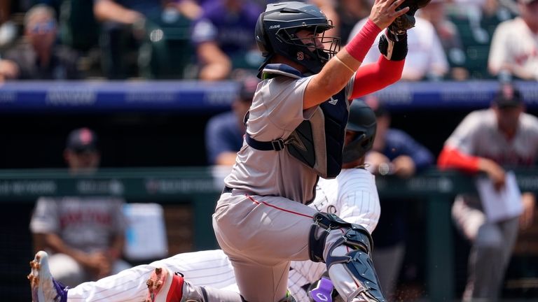 Boston Red Sox catcher Reese McGuire, front, fields the throw...