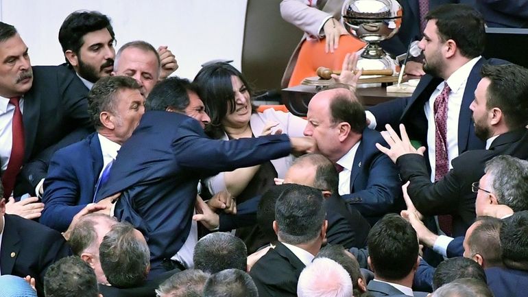 Turkey's ruling AK Party lawmakers scuffle with opposition lawmakers during...