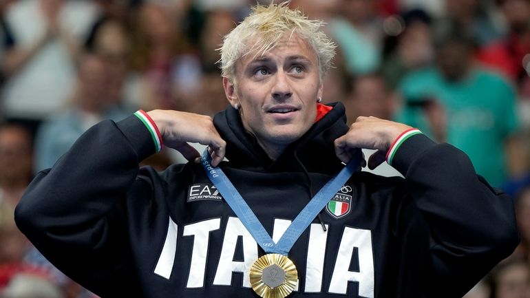 Gold medalist Nicolo Martinenghi reacts on the podium after winning...