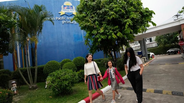 Chinese mother Du Xuan, left, picks up her daughters May...