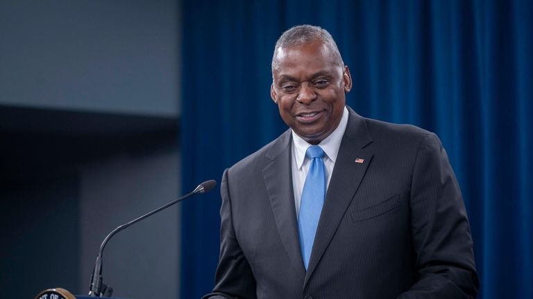 Secretary of Defense Lloyd Austin smiles while answering a question...