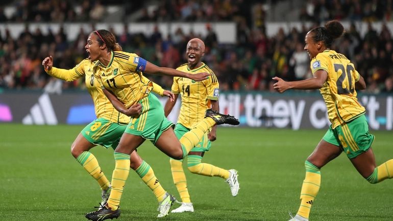 Jamaica's Allyson Swaby, left, celebrates with teammates after scoring the...