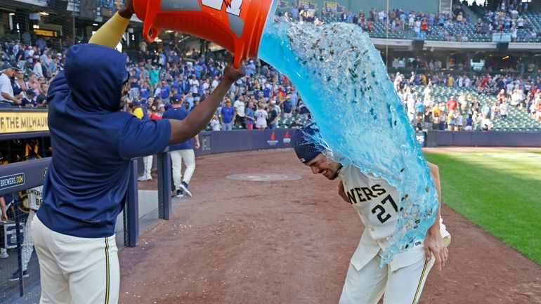 Milwaukee Brewers' Willy Adames, right, is doused after a baseball...