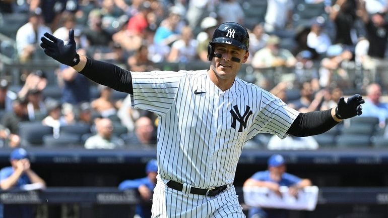 Yankees' Anthony Rizzo reacts to the dugout as he run...