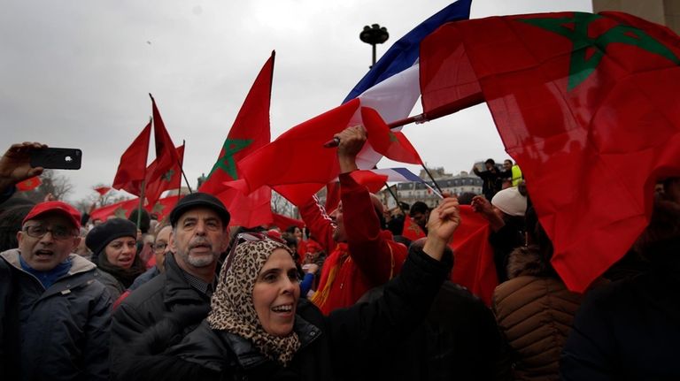 Demonstrators wave Moroccan flags during a protest in Paris on...