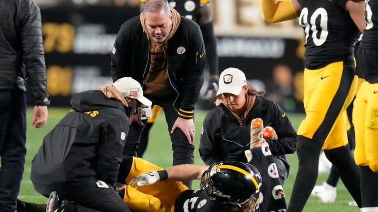 Pittsburgh Steelers linebacker Cole Holcomb (55) is cared for by...