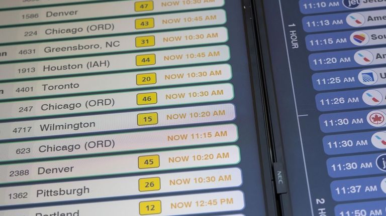 Delayed flight schedules are displayed on a screen at LaGuardia...