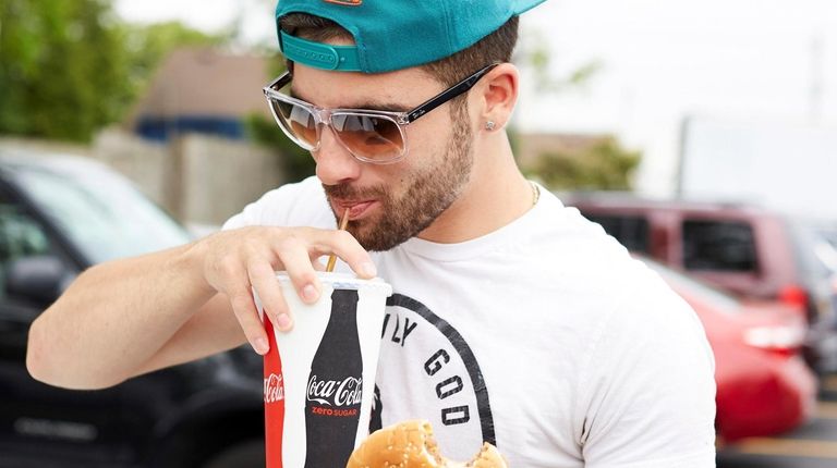 Johnny Manobianco from Farmingdale enjoys his burger at All American Drive-In in Massapequa.