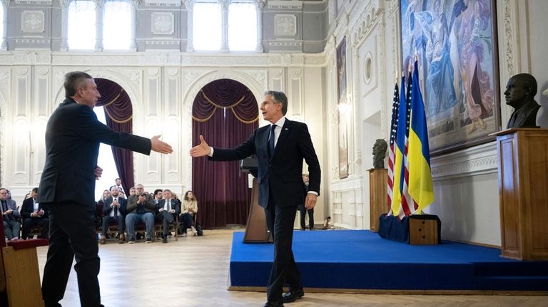 U.S. Secretary of State Antony Blinken, right, leaves the stage...