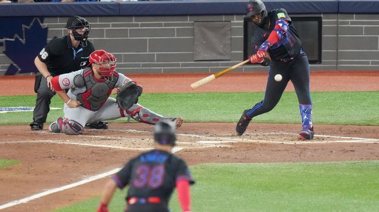 Toronto Blue Jays' Vladimir Guerrero Jr., right, hits an RBI...