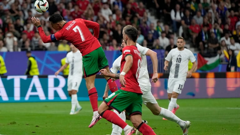 Portugal's Cristiano Ronaldo heads the ball during a round of...