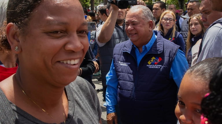 National Electoral Council President Elvis Amoroso, center, smiles after taking...