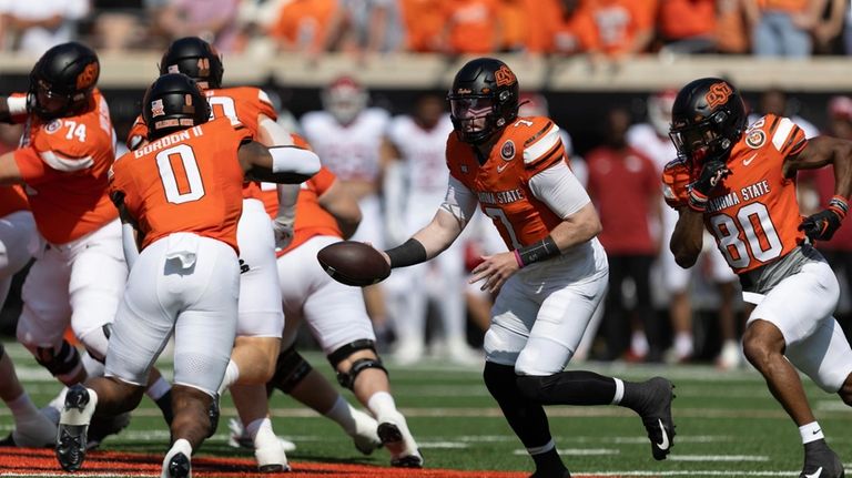 Oklahoma State quarterback Alan Bowman (7) hands the ball off...