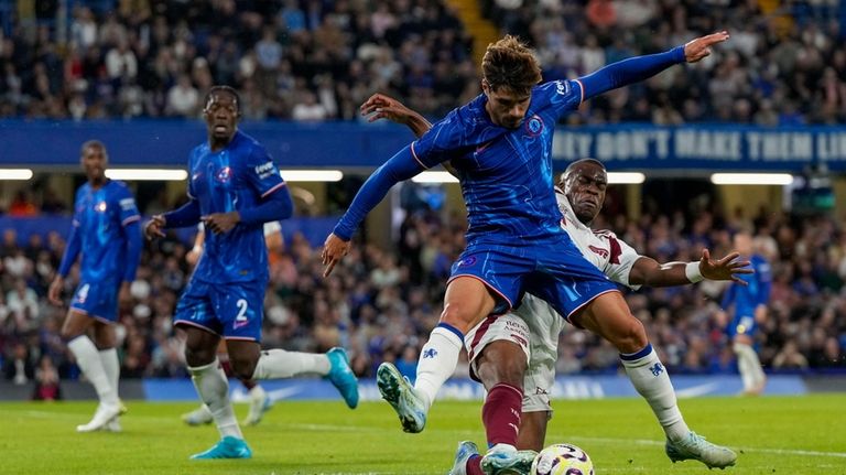 Chelsea's Pedro Neto, front, duels for the ball with Servette's...