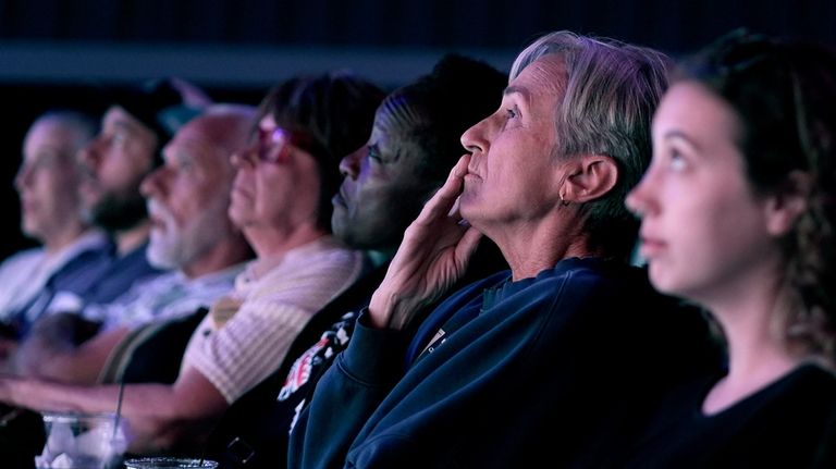 People watch the presidential debate between Republican presidential nominee former...