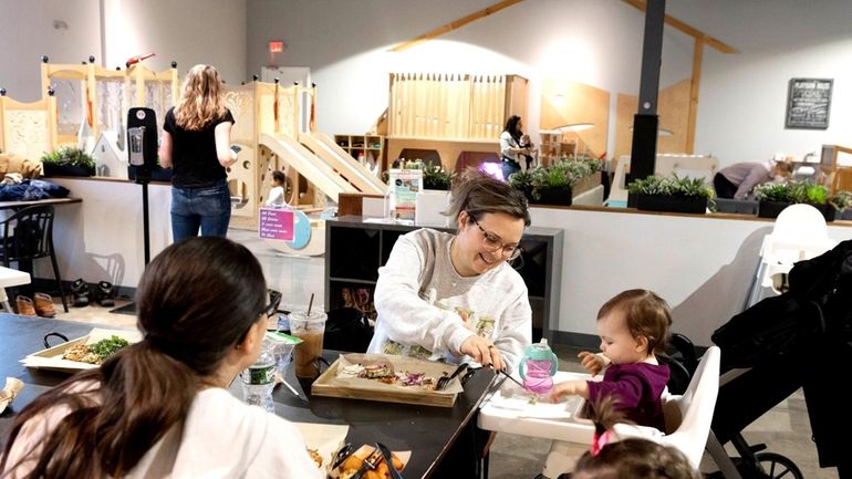 Maureen Tropiano feeds daughter, Rae, at the Social Play Haus...