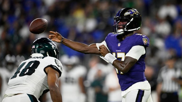 Baltimore Ravens' Josh Johnson, right, passes under pressure from Philadelphia...