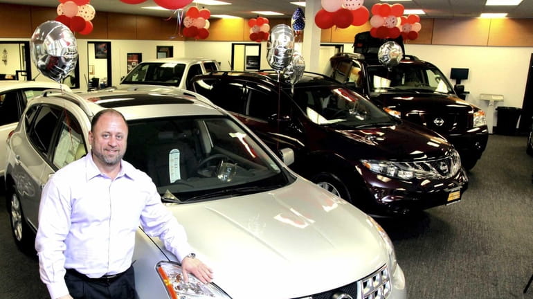 Chris Assmar, general sales manager at Atlantic Nissan, stands with...