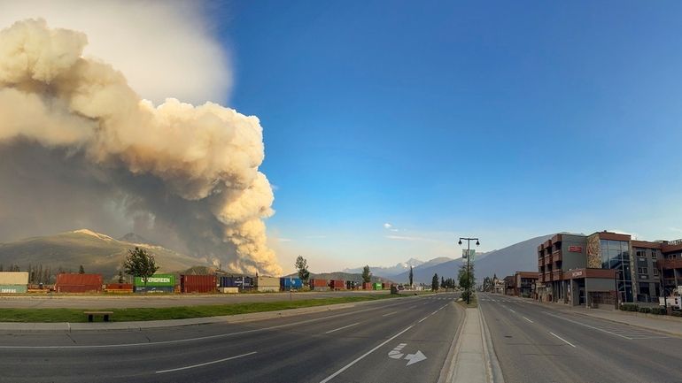 In this photo released by the Jasper National Park, smoke...