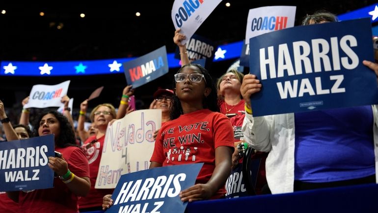 Supporters carry signs as Democratic presidential nominee Vice President Kamala...