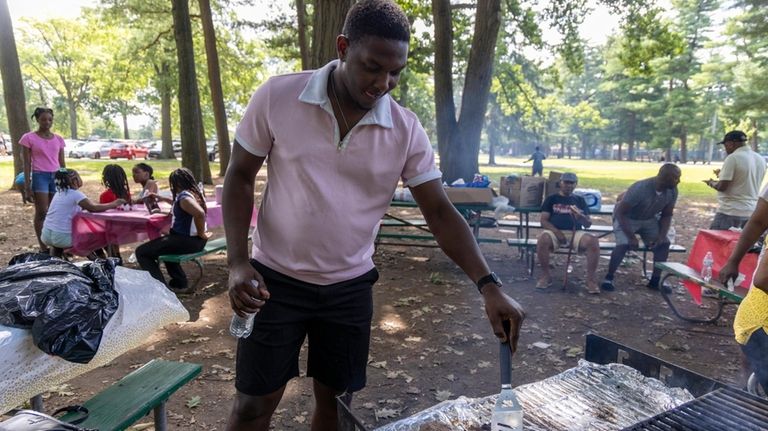 Wilbert Pierre, West Hempstead, works the grill at Eisenhower Park...