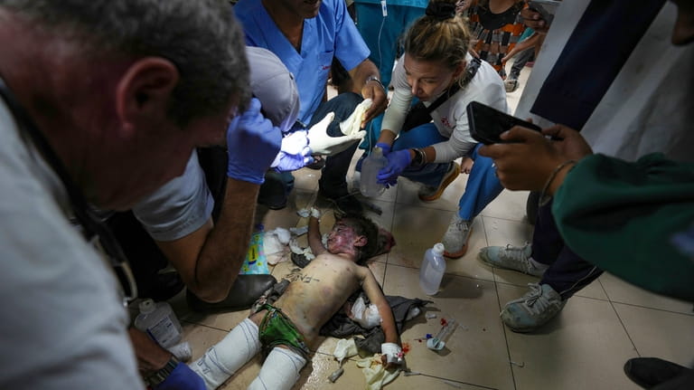 Medics treat a wounded child from an Israeli bombardment of...