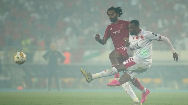 Wydad's Amine Farhane, right, kicks the ball ahead of Al...