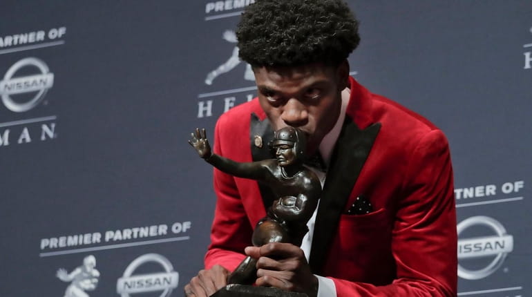 Louisville's Lamar Jackson poses with the Heisman Trophy after winning...