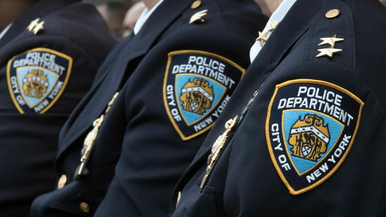 Members of the New York City Police Department listen to...