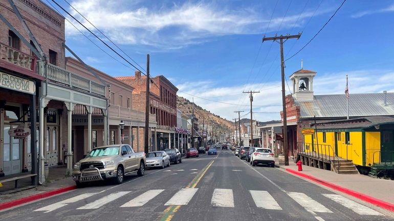 Cars line the main stretch of Virginia City, Nev., that...