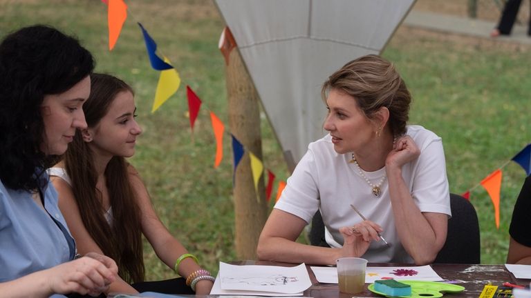 First lady Olena Zelenska talks to a girl during her...