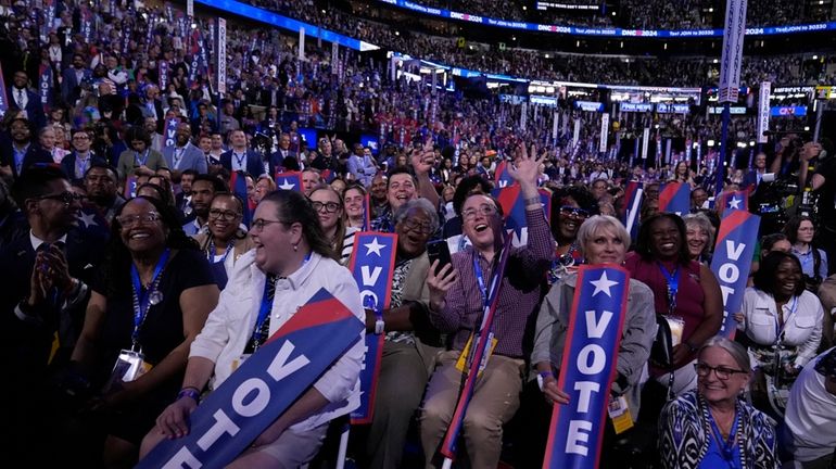 Delegates watch as former President Barack Obama speaks during the...