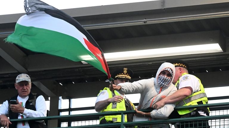 Law enforcement members remove a protester from a train station...