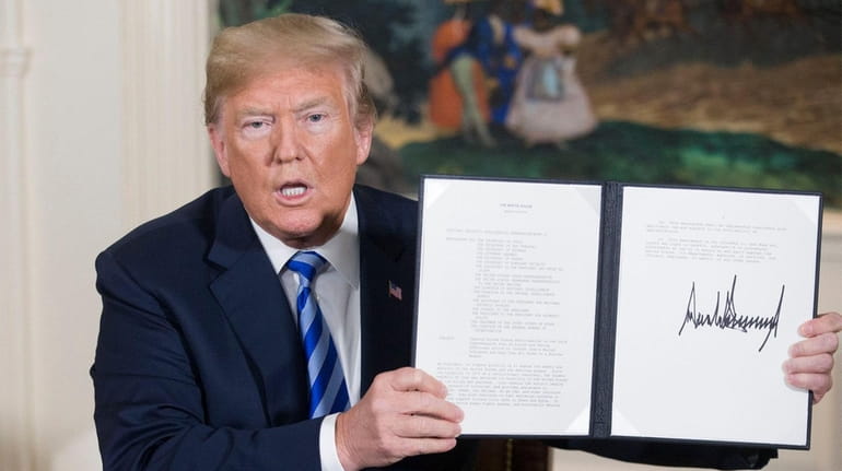 President Donald Trump holds up a national security presidential memorandum...