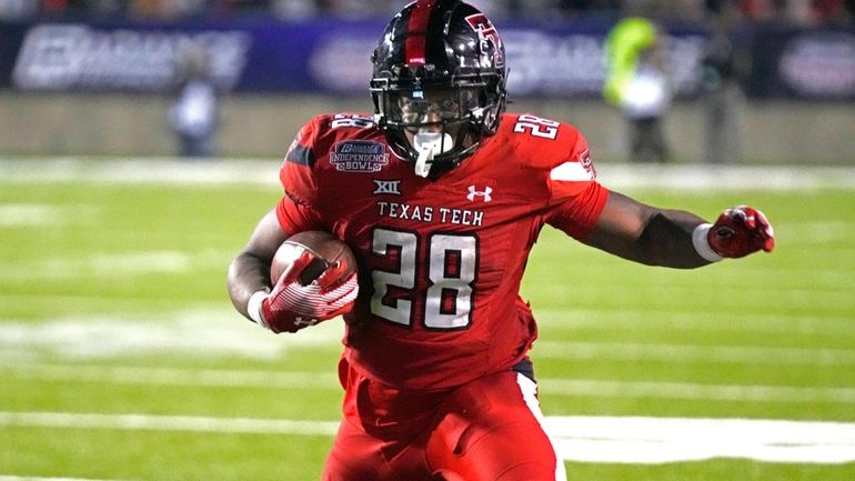 Texas Tech running back Tahj Brooks (28) runs for a...