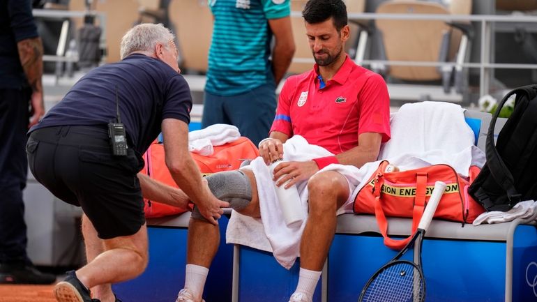 Serbia's Novak Djokovic receives medical treatment during his match against...