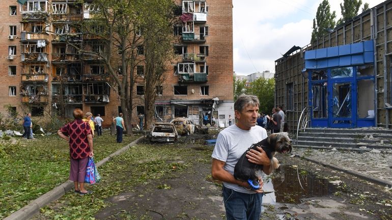 Residents of an apartment building damaged after shelling by the...