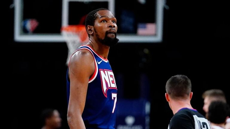 Nets' Kevin Durant (7) looks at the score during the...