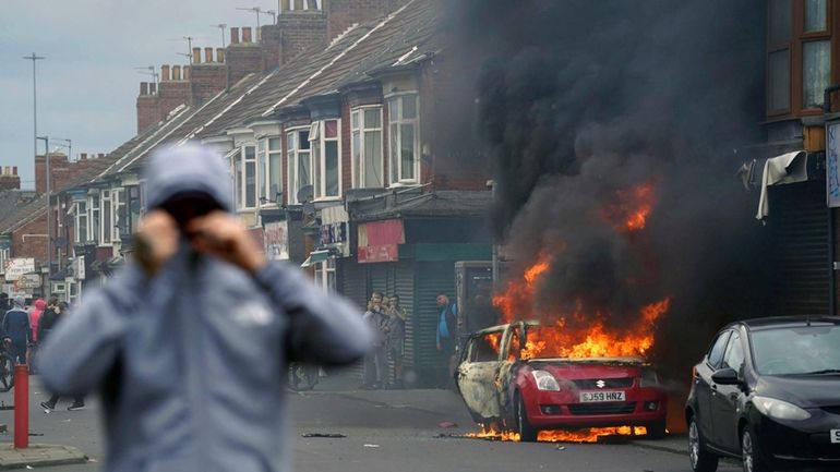 A car burns during an anti-immigration protest in Middlesbrough, England,...