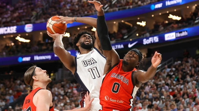 United States center Joel Embiid (11) drives to the basket...