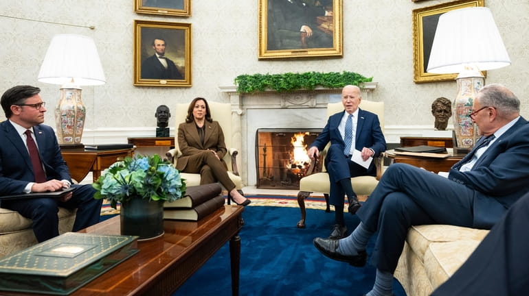 President Joe Biden meets with House Speaker Mike Johnson, left,...