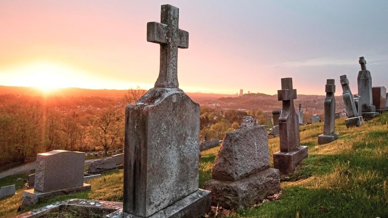 The sun rises on St. Mary's Cemetery, April 19, 2019,...