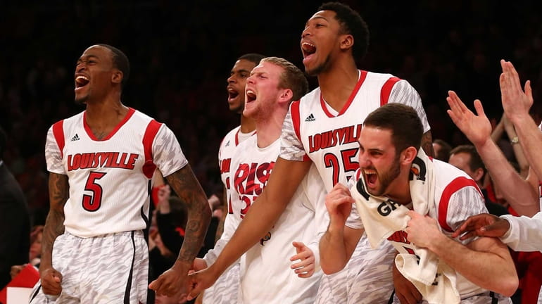 Louisville Cardinals players celebrate on the bench during the Big...