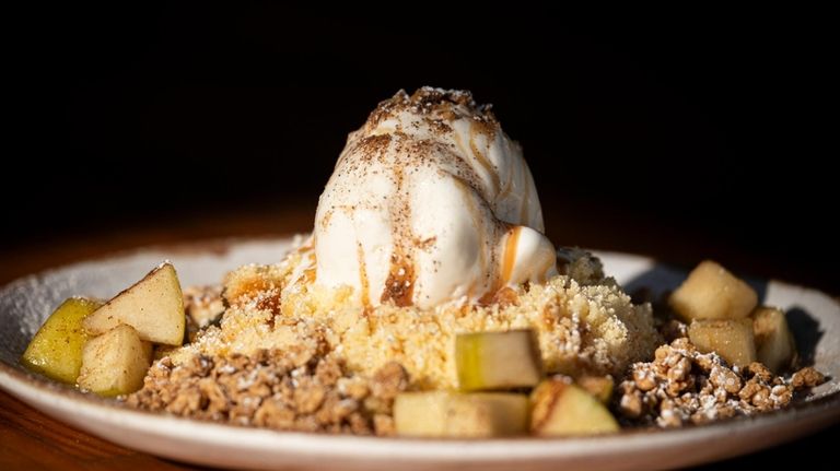 Apple Foster over crumbled cake with vanilla ice cream is...