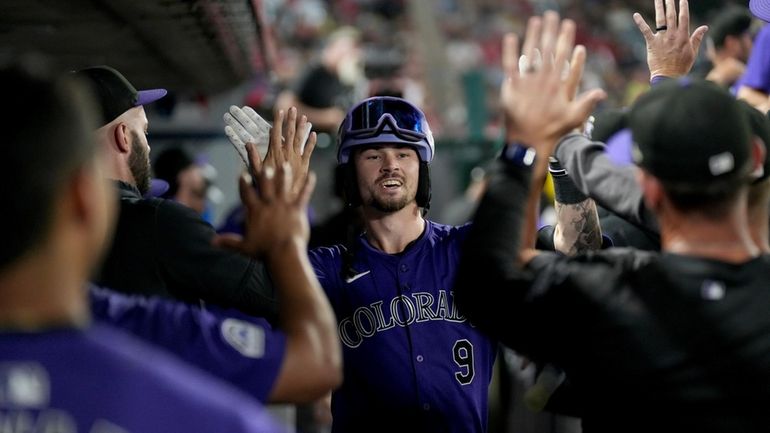 Colorado Rockies' Brenton Doyle (9) celebrates with teammates in the...