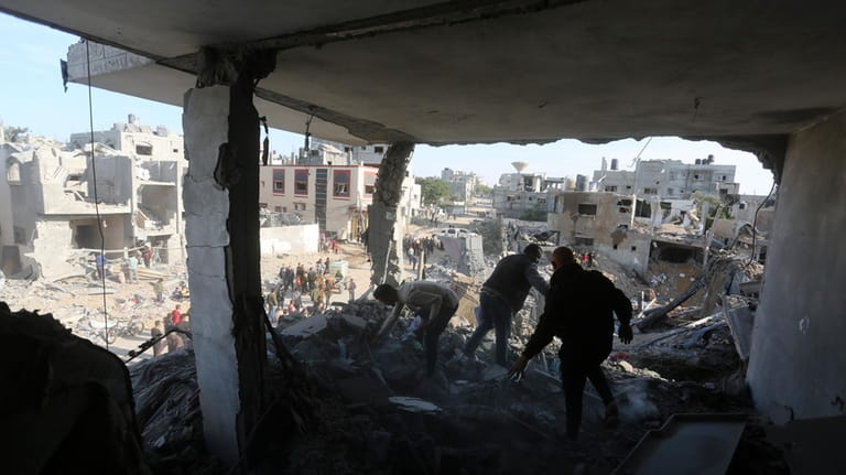 Palestinians look at the destruction by the Israeli bombardment of...