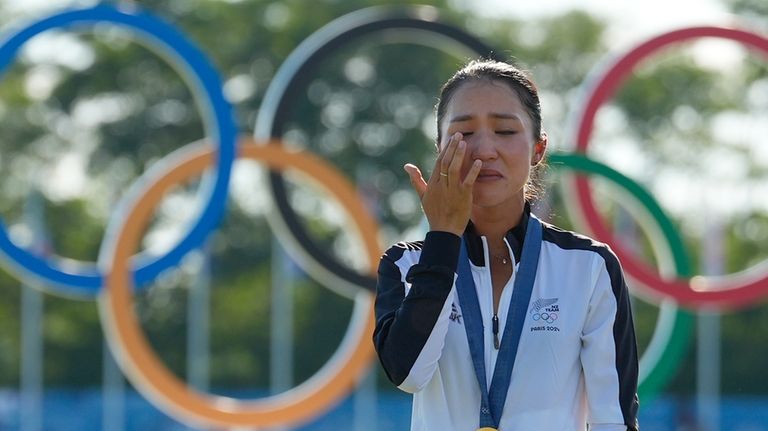 Lydia Ko, of New Zealand, wearing her gold medal cries...