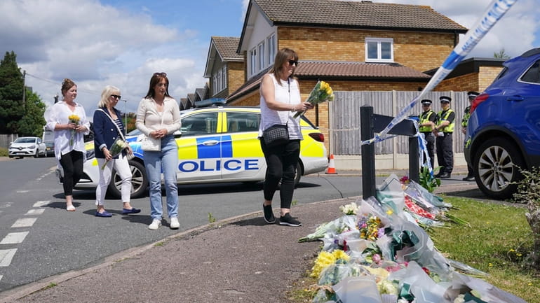 Family friend Lea Holloway, left, arrives with others to place...